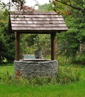 Устройство колодца с отделкой каменной с деревянной крышей
